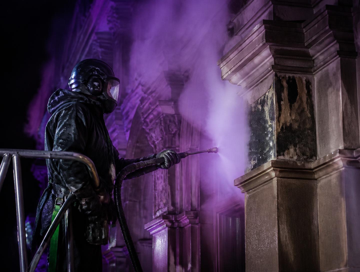 Operator using DOFF steam system on a Victorian sandstone facade